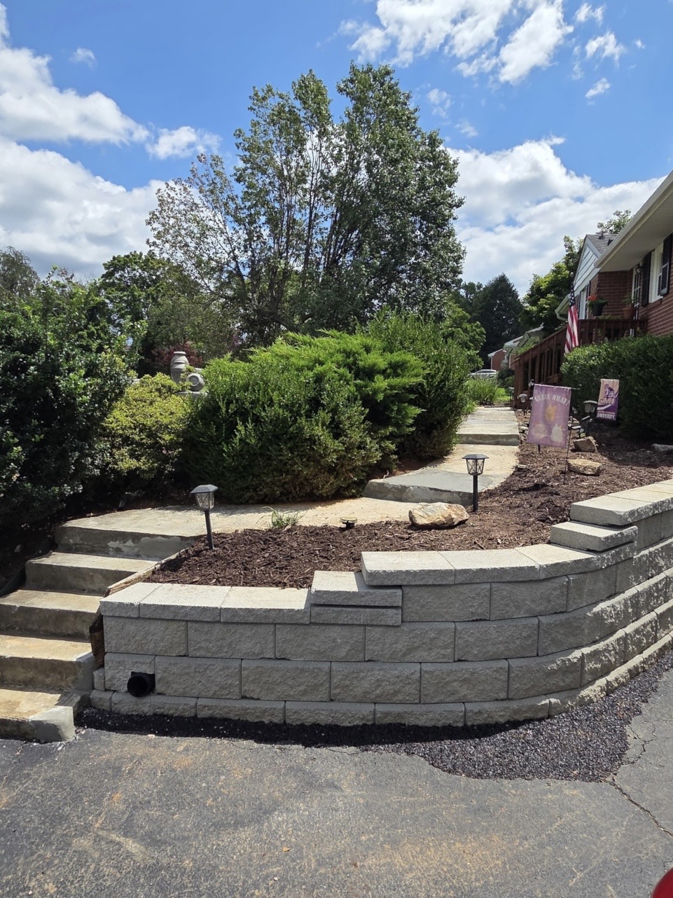 Finished curved block retaining wall with drain outlet at the base and replanted mulch bed, Roanoke, VA